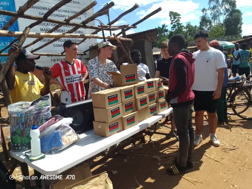 Studenten delen dozen uit op een marktplein in Malawi